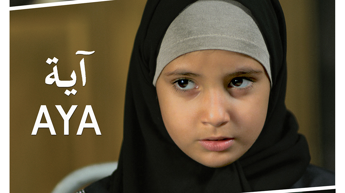 A serious little girl wearing a hijab.